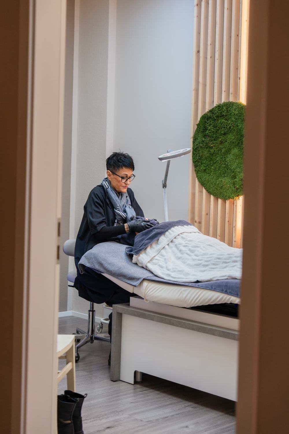 Behandlerin bei der SKINONSKIN Behandlung im Behandlungsraum
